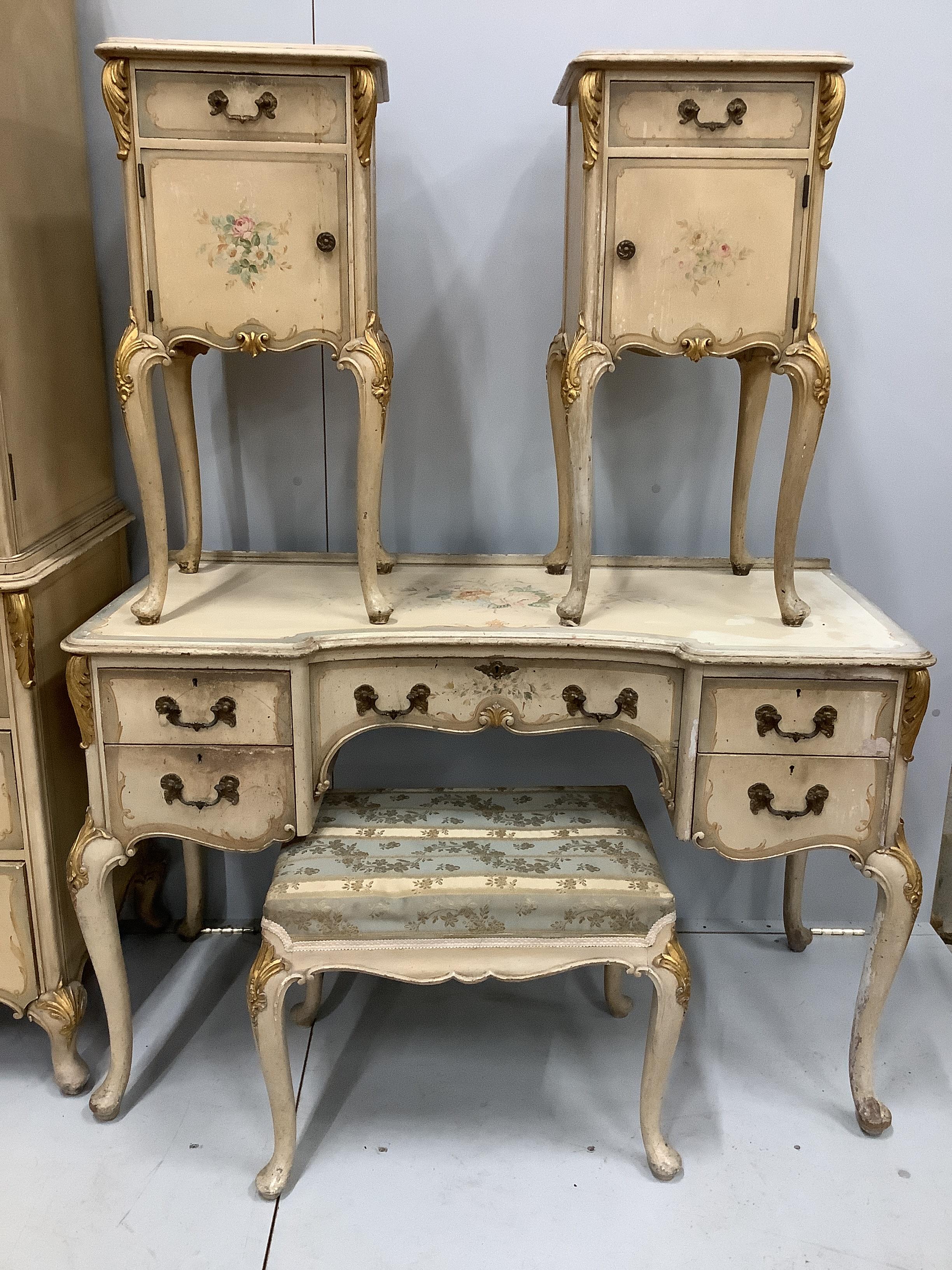 An 18th century style painted seven piece bedroom suite, comprising press cupboard, pair of bedside cabinets, kneehole dressing table, stool, chest of drawers and tub framed side chair